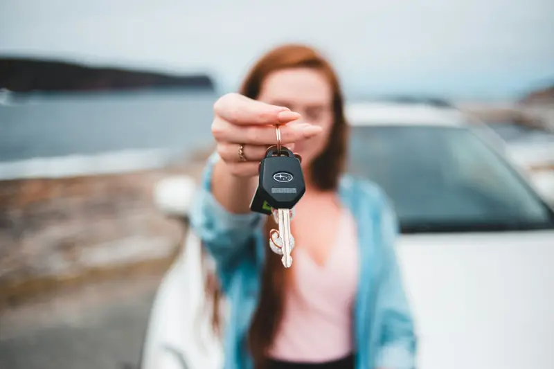 Compradora segurando a chave do carro novo